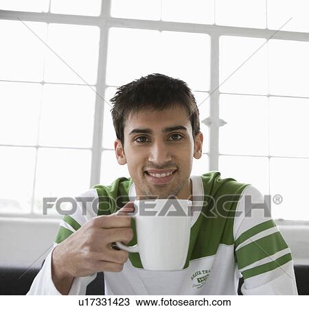 Stock Image - Portrait of a man holding a mug.. Fotosearch