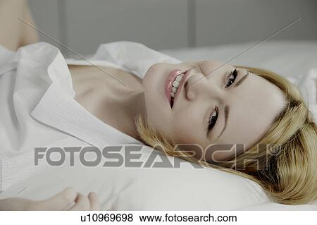 Portrait of a woman laying on a bed. View Large Photo Image Stock Photo - Portrait of a woman laying on a bed.. Fotosearch