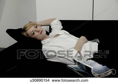 Portrait of a woman, laying on sofa. View Large Photo Image Picture - Portrait of a woman, laying on sofa.. Fotosearch