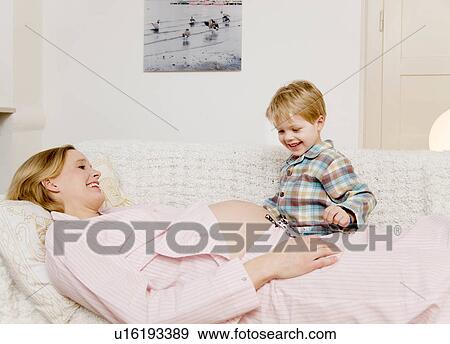 Stock Photo - pregnant woman and boy laughing. Fotosearch