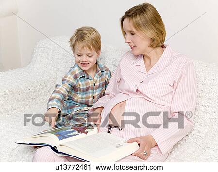 Stock Image - pregnant woman and boy reading book. Fotosearch