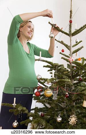 pregnant woman decorating christmas tree View Large Photo Image Stock Photograph - pregnant woman decorating christmas tree. Fotosearch