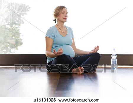 Stock Photograph - pregnant woman doing yoga exercises. Fotosearch