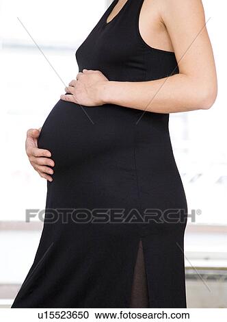 Stock Image - pregnant woman in black dress. Fotosearch