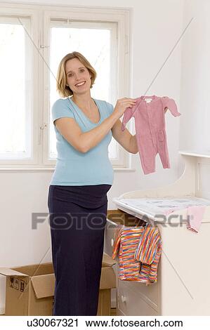 pregnant woman selecting baby clothes View Large Photo Image Stock Image - pregnant woman selecting baby clothes. Fotosearch