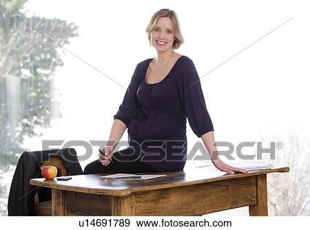 Stock Photo - pregnant woman working in home office. Fotosearch