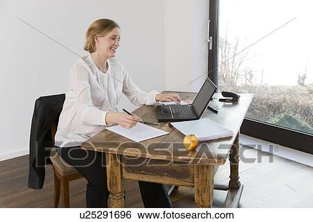 Stock Photograph - pregnant woman working in home office. Fotosearch