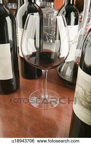 Stock Photograph - Red wine glass and bottles. Fotosearch