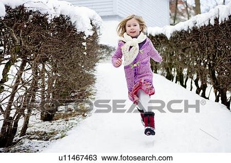 Stock Image - Scandinavian girl running in snow. Fotosearch