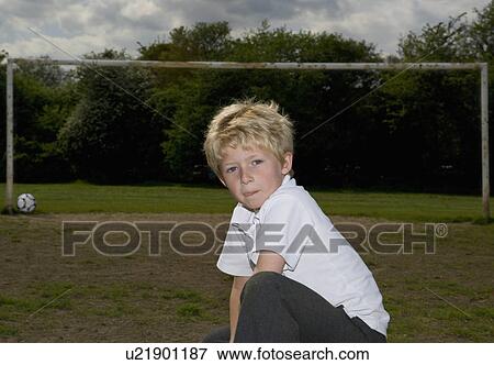 Stock Photo - Schoolboy in front of football goalpost. Fotosearch