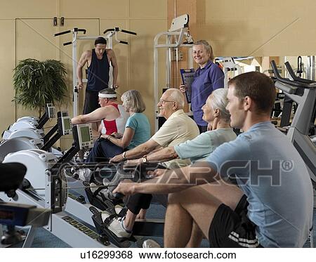 Stock Photo - seniors training at gym with instructor. Fotosearch