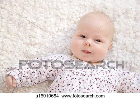smiling baby lying on white blanket View Large Photo Image Picture - smiling baby lying on white blanket. Fotosearch