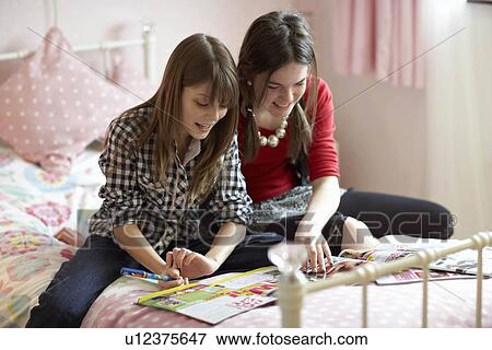 Teenage girls reading magazines View Large Photo Image Stock Photo - Teenage girls reading magazines. Fotosearch