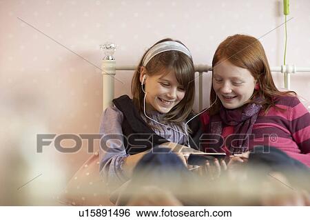 Teenage girls sharing music player View Large Photo Image Stock Photograph - Teenage girls sharing music player. Fotosearch