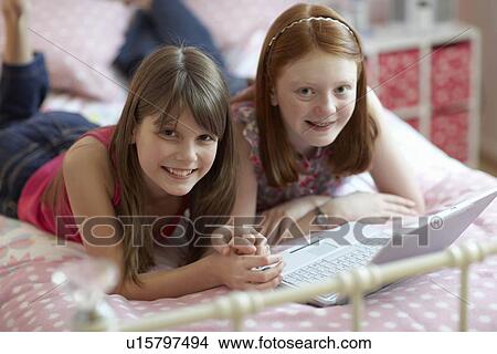 Picture - Teenage girls using laptop. Fotosearch