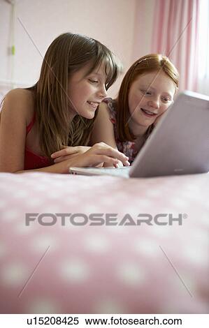 Teenage girls using laptop View Large Photo Image Stock Photography - Teenage girls using laptop. Fotosearch