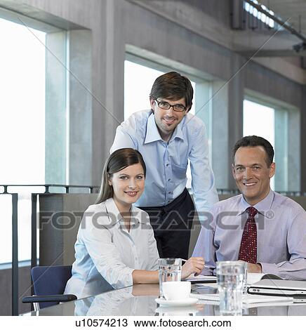 Three Businesspeople at table View Large Photo Image Stock Image - Three Businesspeople at table. Fotosearch