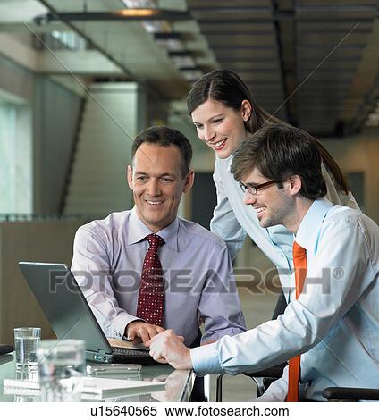 Three Businesspeople looking on laptop View Large Photo Image Stock Photography - Three Businesspeople looking on laptop. Fotosearch