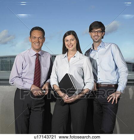 Three Businesspeople, smiling, standing View Large Photo Image Stock Image - Three Businesspeople, smiling, standing. Fotosearch