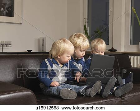 Three toddlers working on laptop View Large Photo Image Stock Photo - Three toddlers working on laptop. Fotosearch