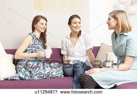 Stock Photo - Three women on a sofa, chatting.. Fotosearch