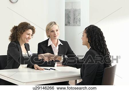 Two business women conduct an interview View Large Photo Image Stock Photograph - Two business women conduct an interview. Fotosearch