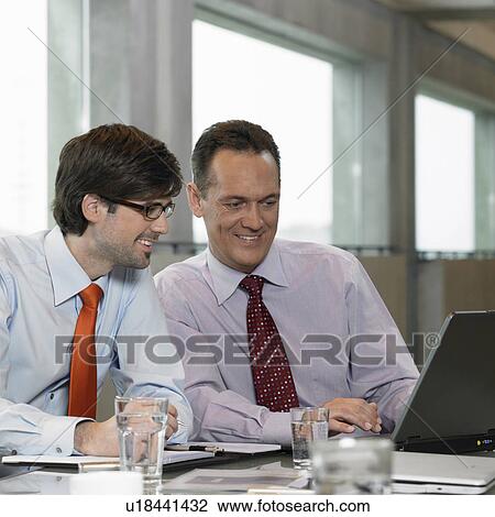 Two Businessmen looking on laptop View Large Photo Image Stock Image - Two Businessmen looking on laptop. Fotosearch