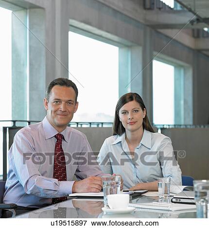 Two Businesspeople sitting at table View Large Photo Image Stock Photo - Two Businesspeople sitting at table. Fotosearch