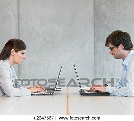 Two Businesspeople using laptops View Large Photo Image Stock Image - Two Businesspeople using laptops. Fotosearch