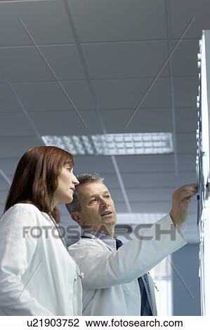 Stock Image - Two doctors looking at x-rays. Fotosearch