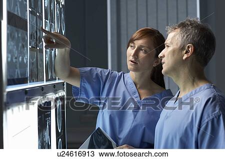 Stock Image - Two doctors looking at x-rays. Fotosearch