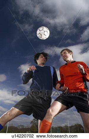 two footballers jumping for football View Large Photo Image Stock Image - two footballers jumping for football. Fotosearch