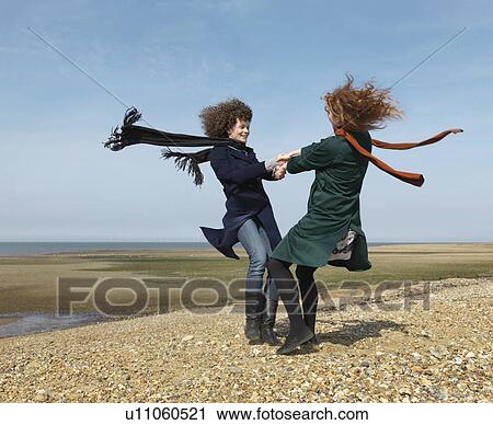 Two friends spinning each other around View Large Photo Image Stock Image - Two friends spinning each other around. Fotosearch