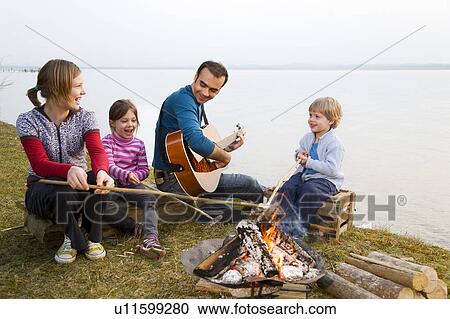 two girls, boy and man roasting sausages View Large Photo Image Stock Image - two girls, boy and man roasting sausages. Fotosearch