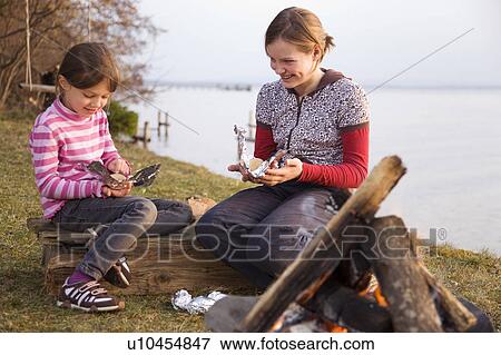 two girls wrapping potatoes for barbecue View Large Photo Image Stock Photo - two girls wrapping potatoes for barbecue. Fotosearch