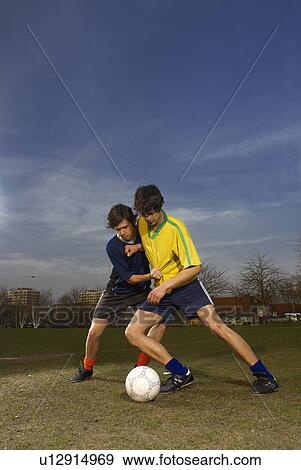 Stock Photo - two men playing football. Fotosearch