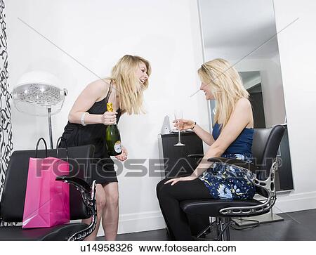 Stock Photograph - Two women at hairdressers with champagne. Fotosearch