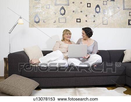 Two women chatting on the couch. View Large Photo Image Stock Image - Two women chatting on the couch.. Fotosearch