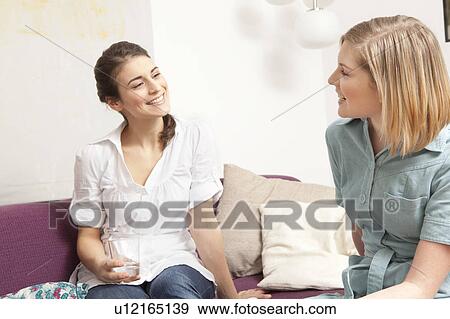 Two women on a sofa, chatting. View Large Photo Image Stock Photo - Two women on a sofa, chatting.. Fotosearch