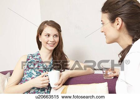 Two women on a sofa, chatting. View Large Photo Image Stock Photography - Two women on a sofa, chatting.. Fotosearch