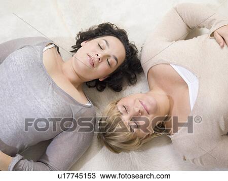 Two women relaxing on the floor View Large Photo Image Stock Image - Two women relaxing on the floor. Fotosearch