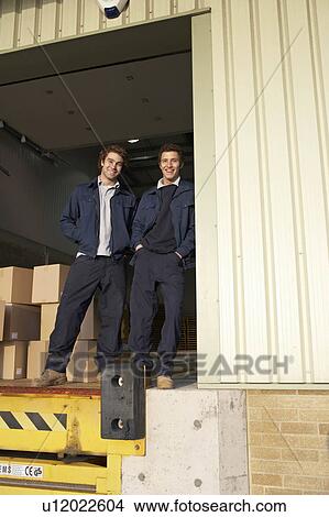 Two workers in warehouse doorway View Large Photo Image Picture - Two workers in warehouse doorway. Fotosearch
