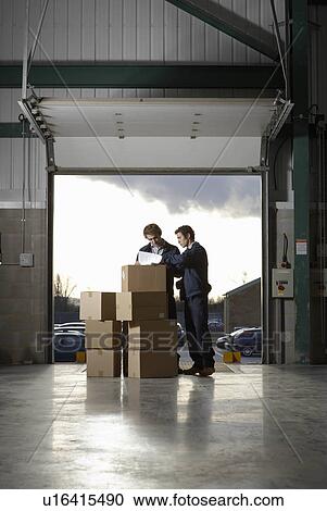 Stock Image - Two workers in warehouse. Fotosearch