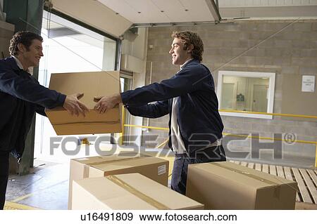 Two workers passing box View Large Photo Image Stock Photo - Two workers passing box. Fotosearch
