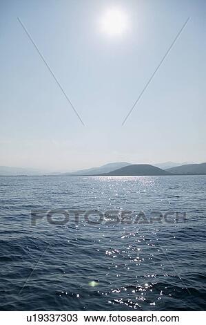Stock Image - View of hilly coastline on sunny day. Fotosearch