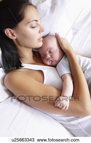 Woman and her baby sleeping in bed View Large Photo Image Stock Image - Woman and her baby sleeping in bed. Fotosearch