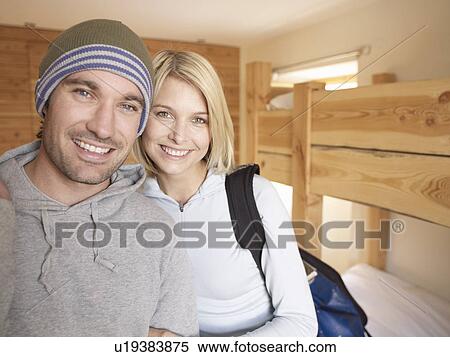 Stock Photography - woman and man looking at viewer hugging. Fotosearch
