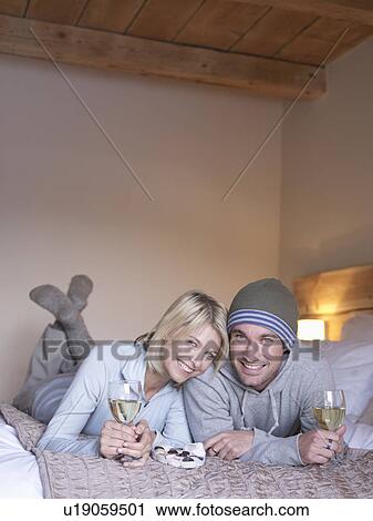 Stock Image - woman and man lying smiling at viewer. Fotosearch