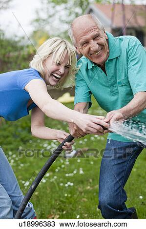 woman and old man playing with hose View Large Photo Image Stock Image - woman and old man playing with hose. Fotosearch