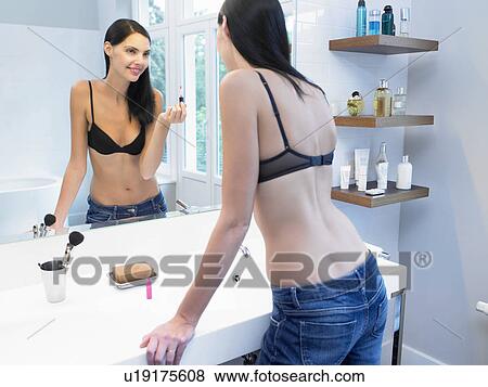 Woman applying makeup in bathroom View Large Photo Image Stock Photo - Woman applying makeup in bathroom. Fotosearch